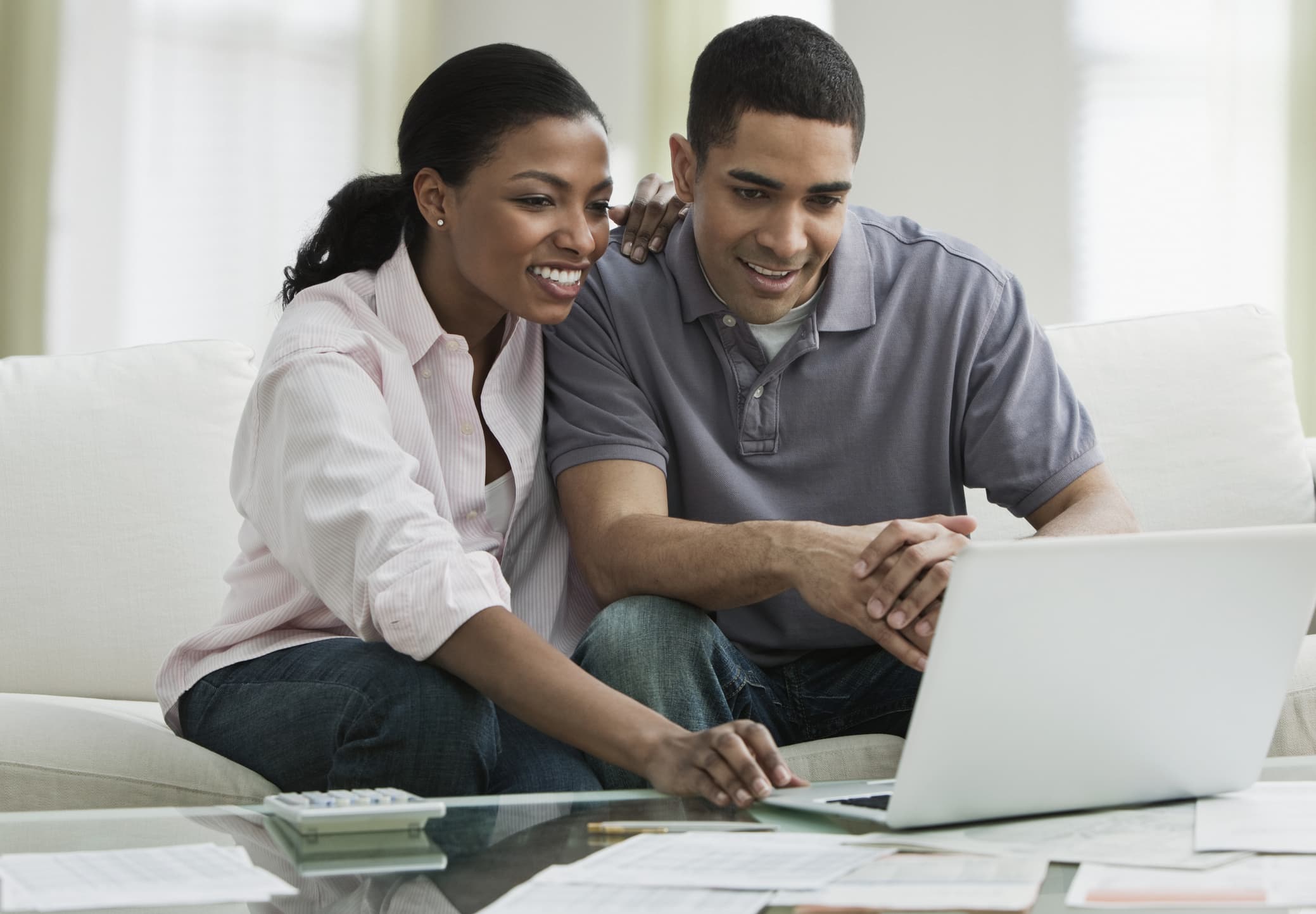 Young african american couple paying bills online with a laptop computer